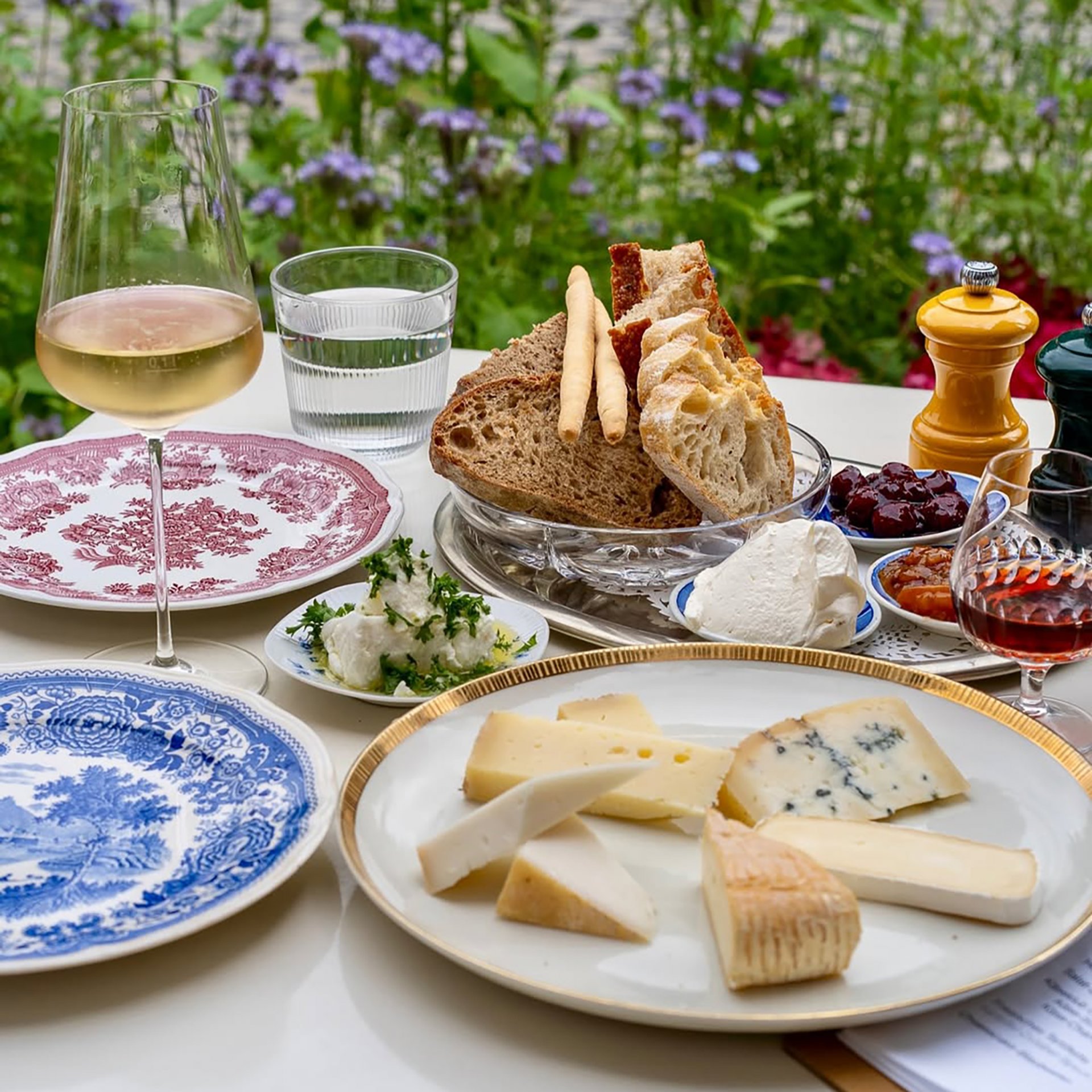 Gedeckter Tisch mit Käseplatte, Wein und Brot