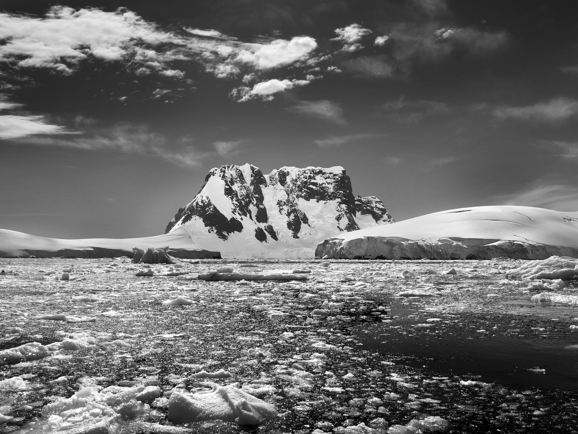 Berg vor Meer mit Eisschollen, Schwarz-Weiß Fotografie